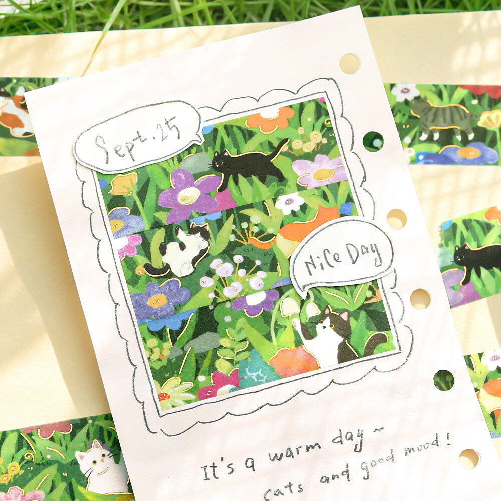 A card with washi designed on it showing a cate and flowers on a garden bed