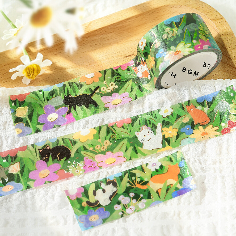 A close-up of a washi design featuring a cat and flowers on a wooden surface.

