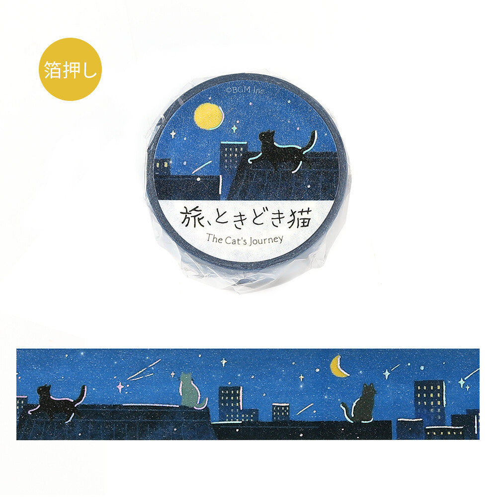 A roll of decorative tape wrapped in clear plastic with a circular label reading 'The Cat's Journey,' shown above an unwrapped strip of the same design. The tape features a dark blue night sky with stars, a yellow moon, and black cat silhouettes sitting on rooftops above city buildings.