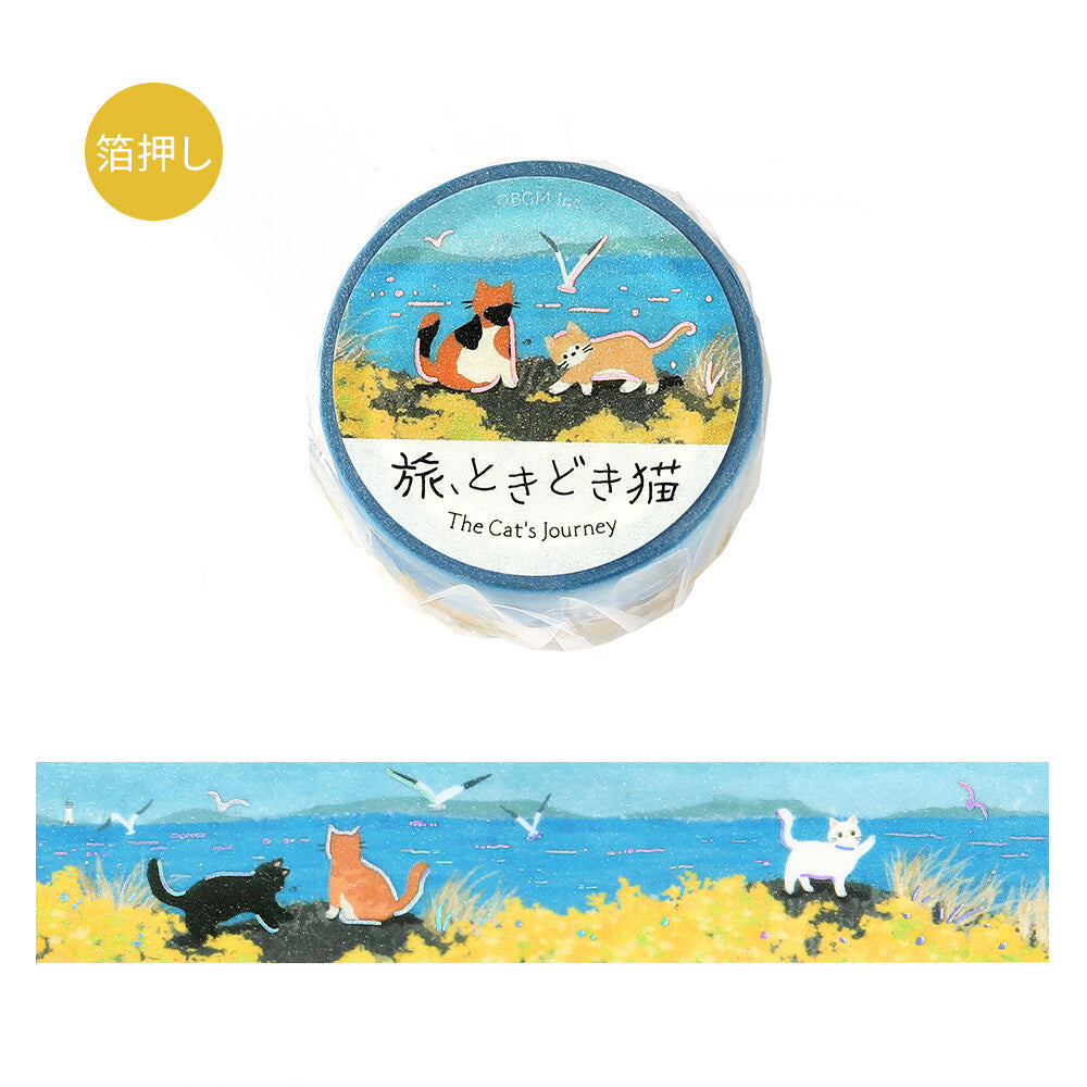 A roll of decorative tape wrapped in clear plastic with a circular label reading 'The Cat's Journey,' shown above an unwrapped strip of the same design. The tape features a cats sitting by a bay enjoying the breeze

