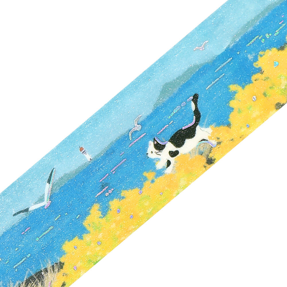A diagonal strip of illustrated scenery on a white background, showing a black-and-white cat running along a yellow flowered shore beside a bright blue sea with seagulls in the water.