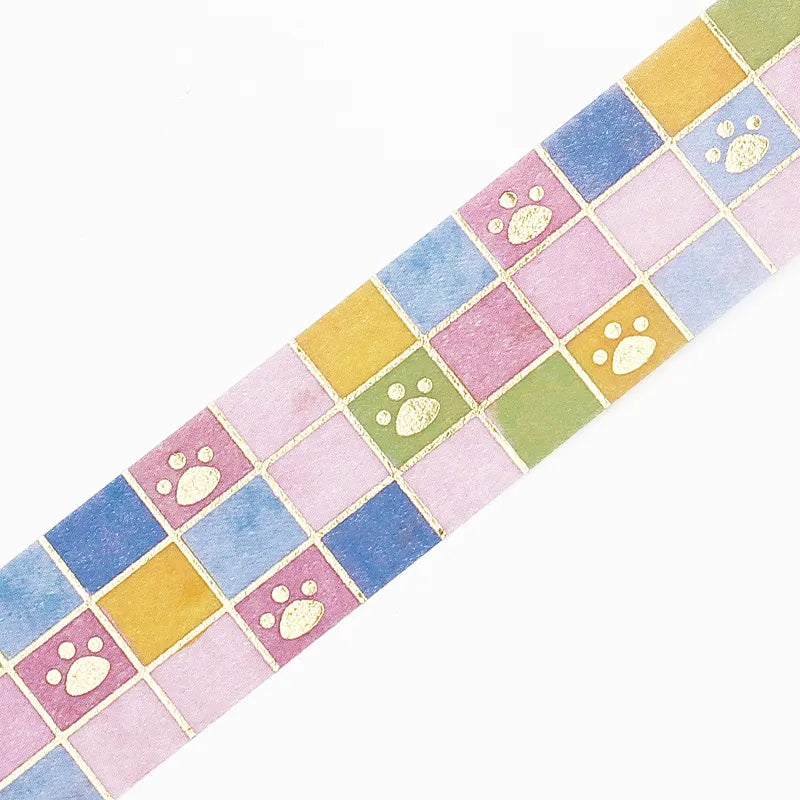 Washi tape with tile art design and gold foil dog paw prints on a white background