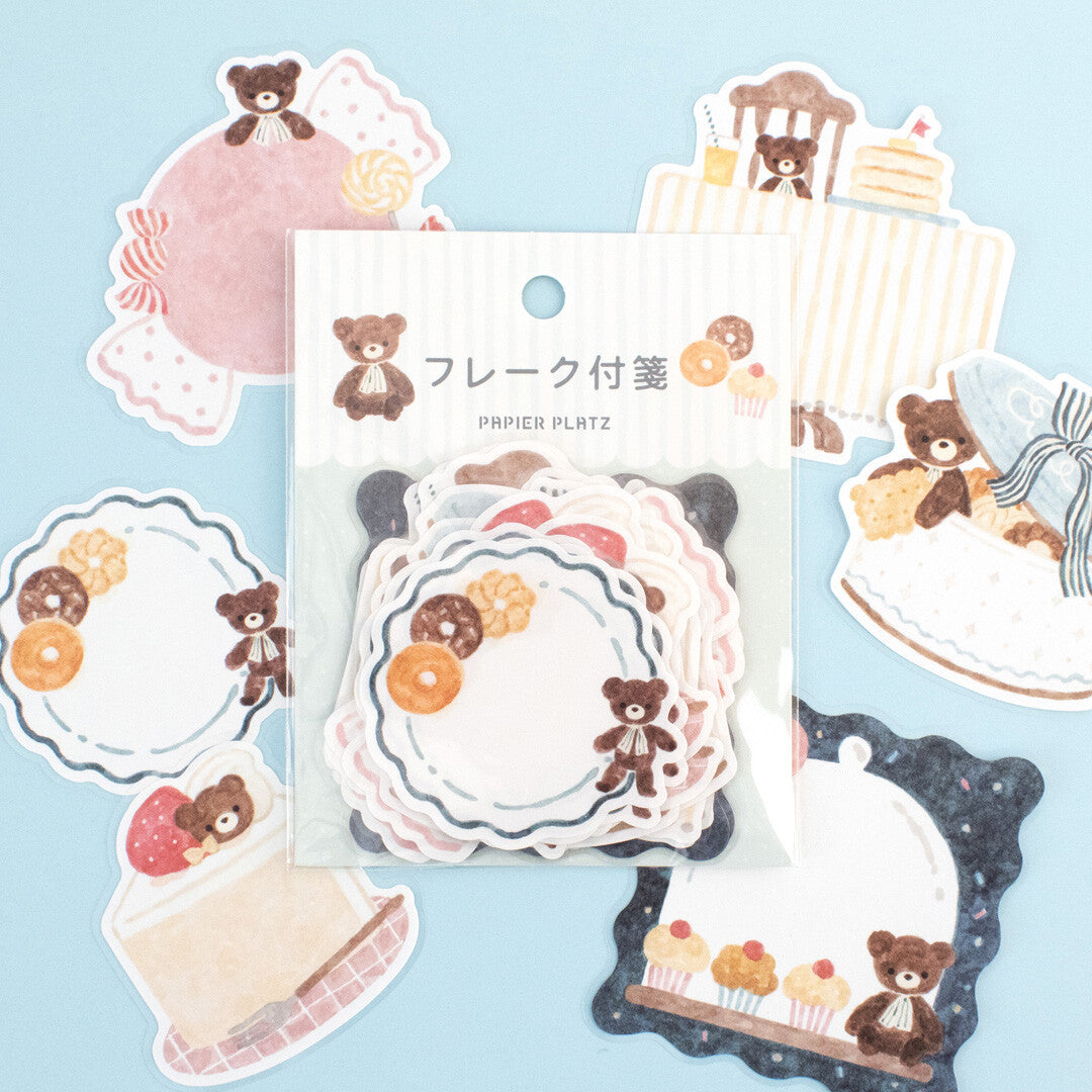 Set of decorative paper stickers with teddy bears and cakes on a light blue background