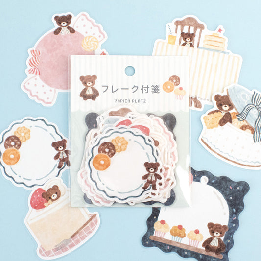 Set of decorative paper stickers with teddy bears and cakes on a light blue background