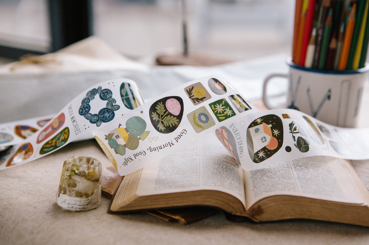 Open book with decorative stickers on a surface