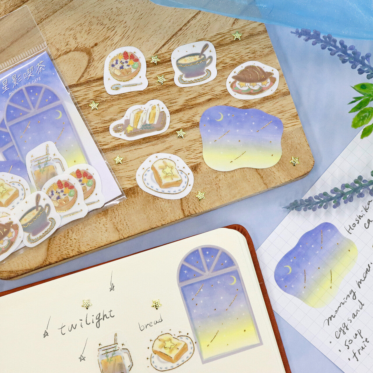 Sticker set with food and window designs on a wooden surface and notebook.