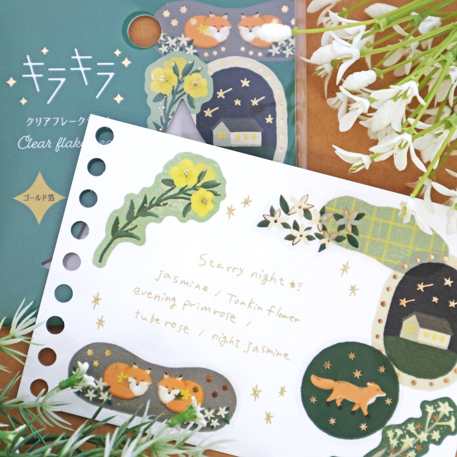 Clear flake sheet with fox and floral designs on a wooden surface with flowers.