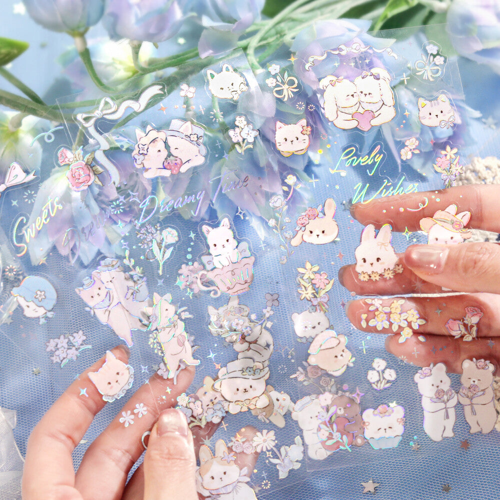 Sheet of decorative stickers with cute animal designs on a blue background, held by hands.