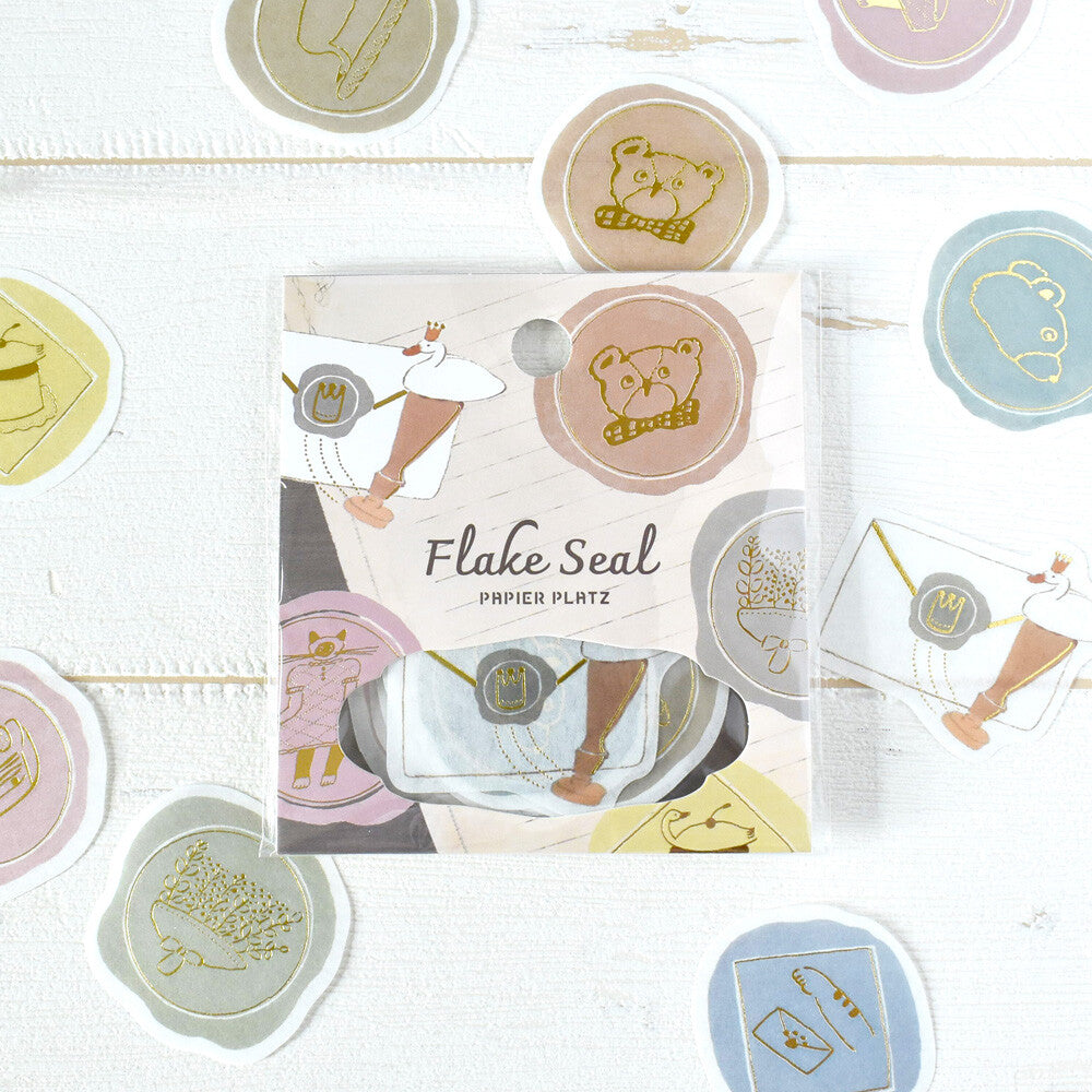 Flake Seal packaging with decorative stickers on a light wooden surface