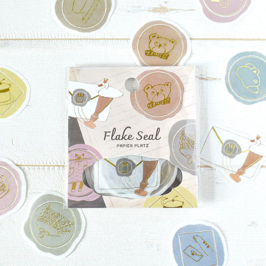 Flake Seal packaging with decorative stickers on a light wooden surface