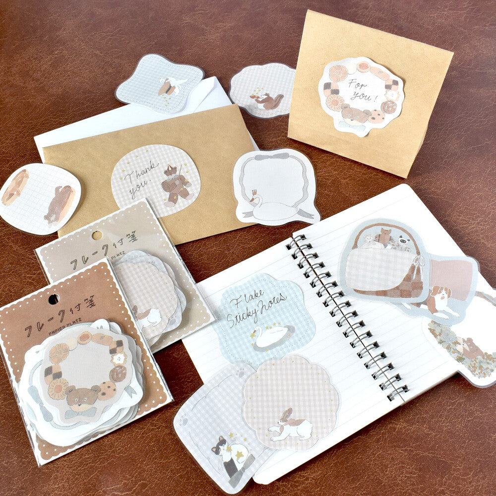 Set of cute stationery items including post-it notes and envelopes on a brown surface