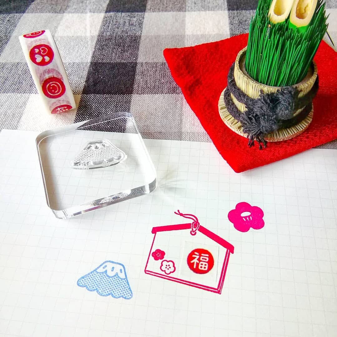 Decorative items including a small plant, a bottle, and a set of stamps on a checkered tablecloth.