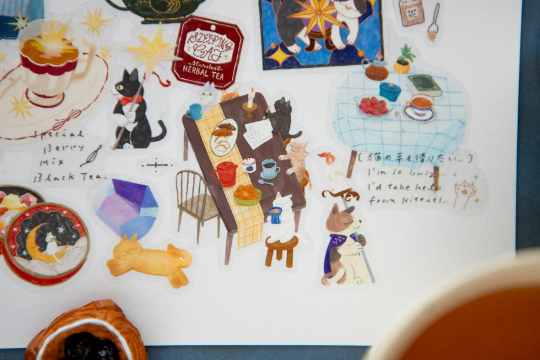 Layered clear stickers on a white paper of cats having tea together