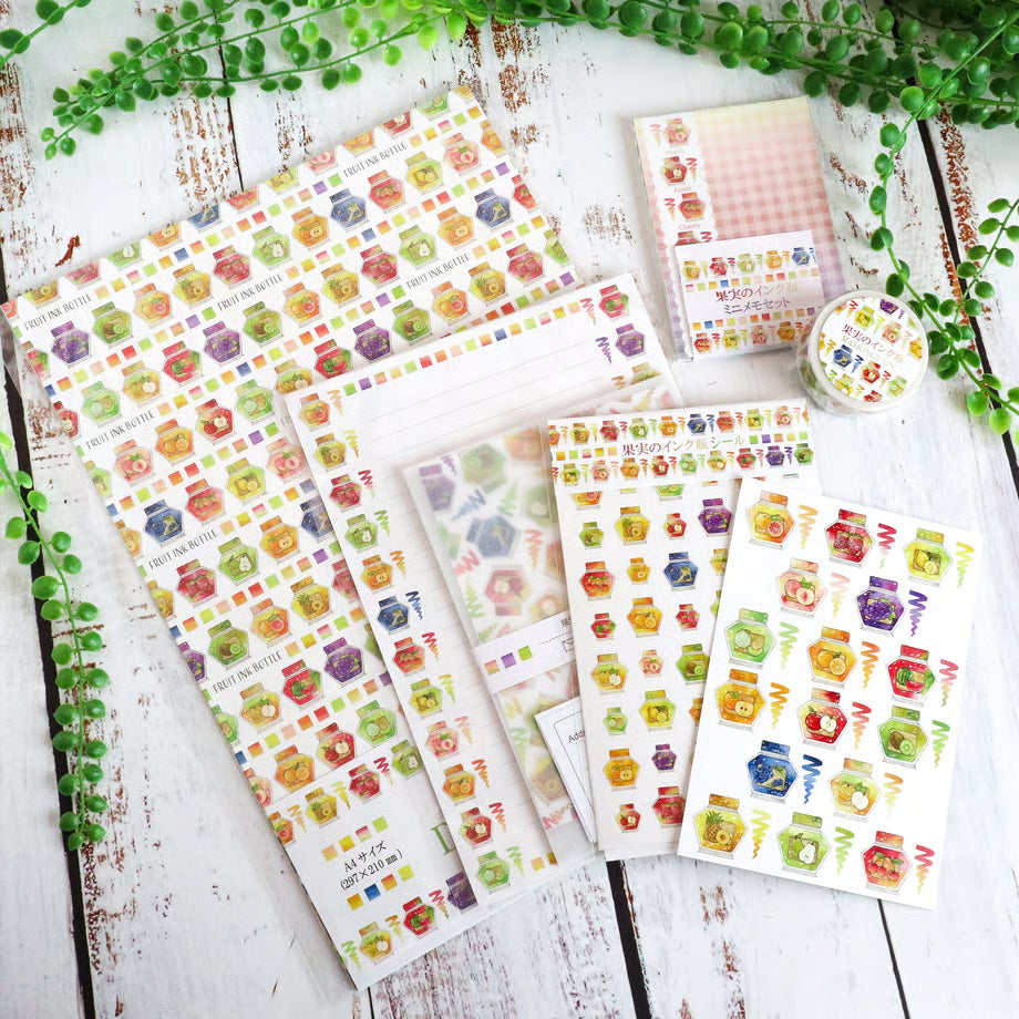 Set of colorful sticker sheets on a wooden surface with greenery.