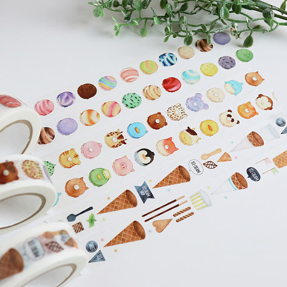 Colorful food-themed stickers on a white background with a roll of tape and green leaves.
