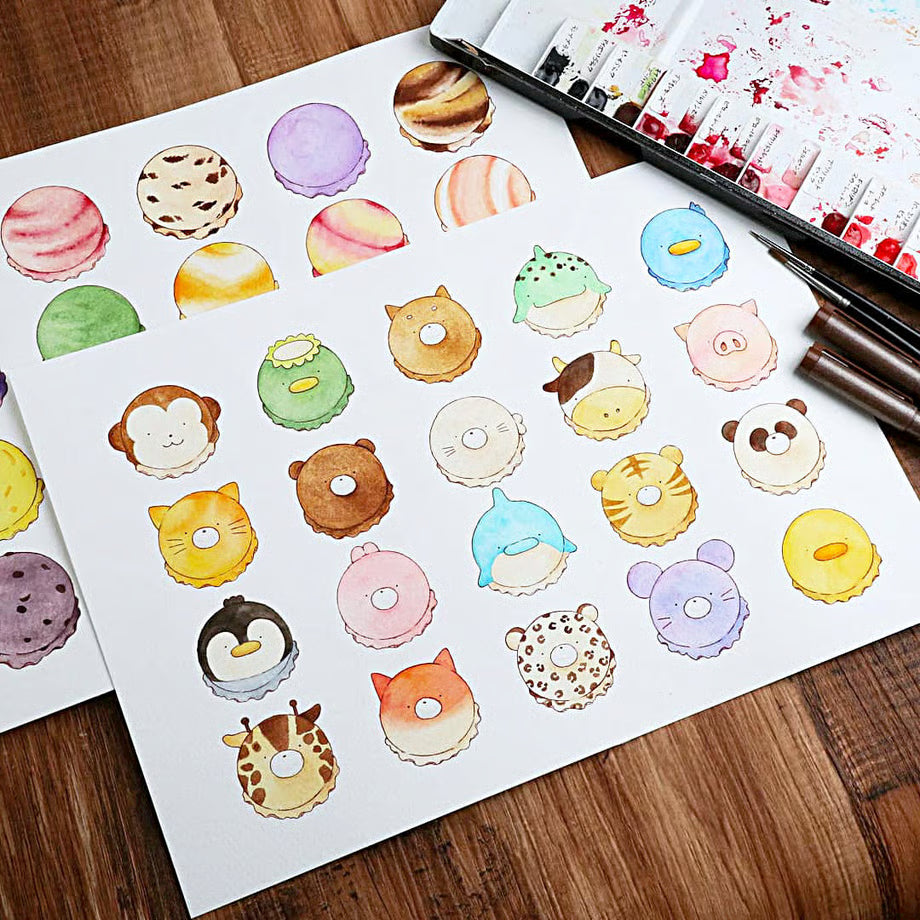 Sheet of colorful animal-themed stickers on a wooden surface with a pen and art supplies.