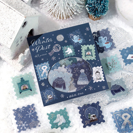 Collection of winter-themed decorative stamps on a snowy surface with a card labeled 'Winter Post'.