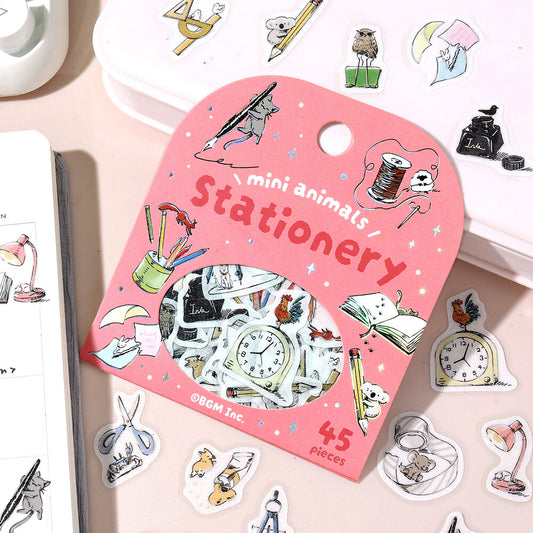 Pink stationery set packaging with illustrations of small animals and stationery items on a light pink background.