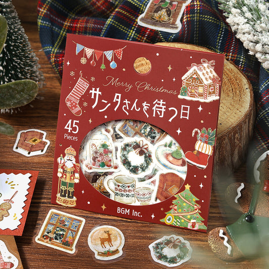 Box of Christmas-themed stickers with decorative elements on a wooden surface.
