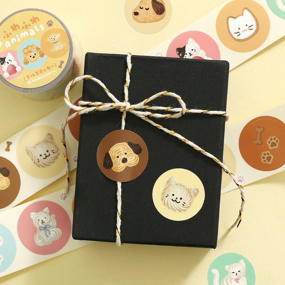 Black gift box with decorative string, surrounded by animal-themed stickers on a yellow background