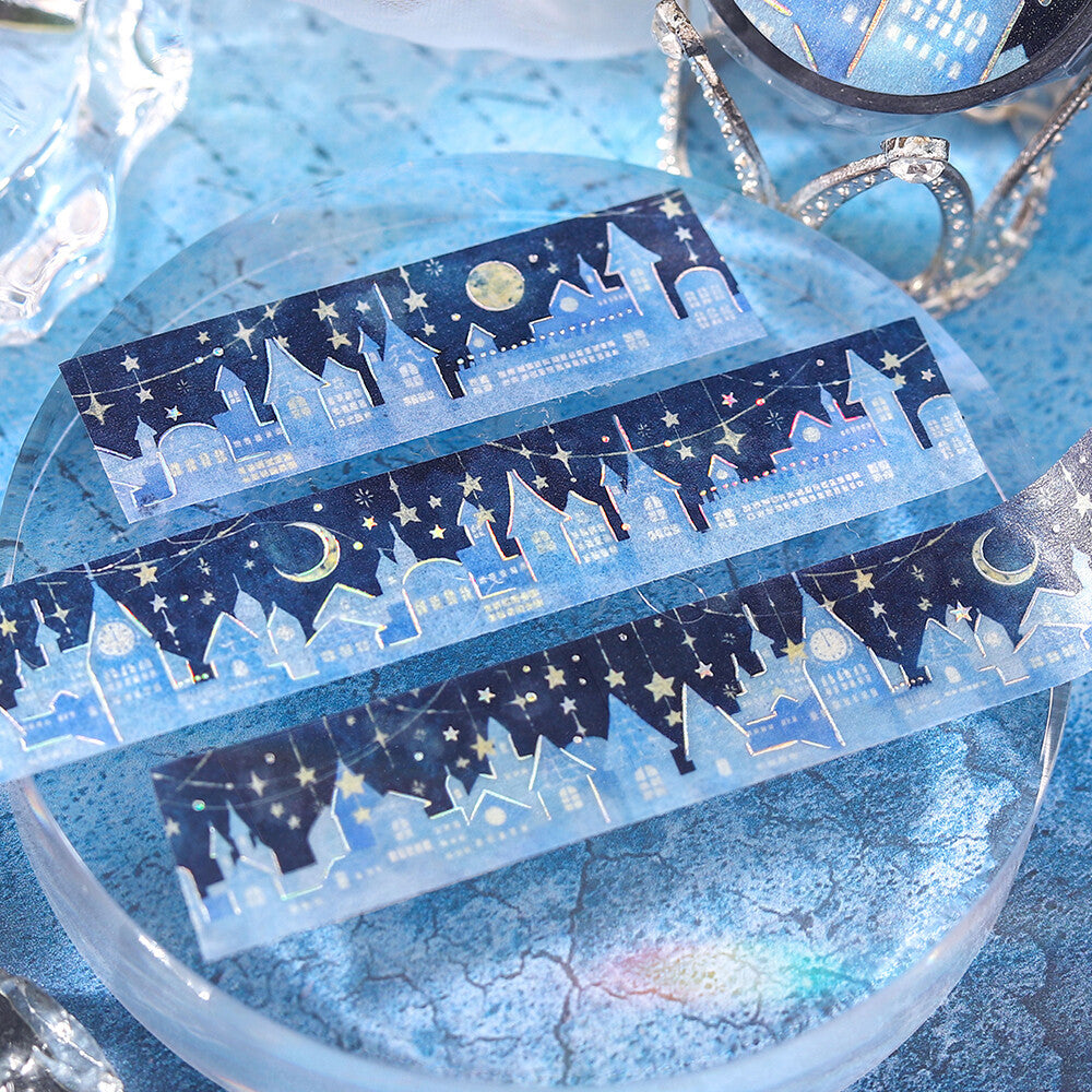 Decorative tape with night sky design featuring houses, stars, and moons on a blue background.