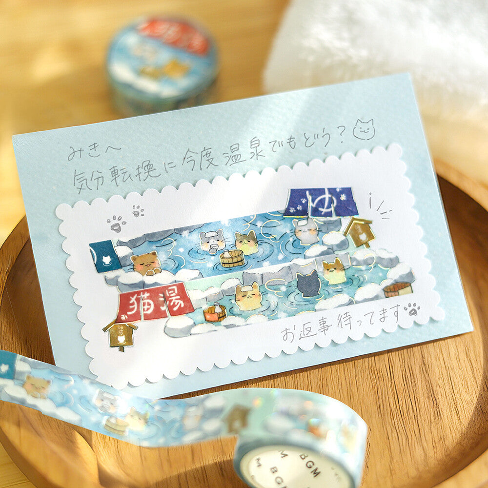 Decorative washi tape with cartoon cat designs on a wooden surface