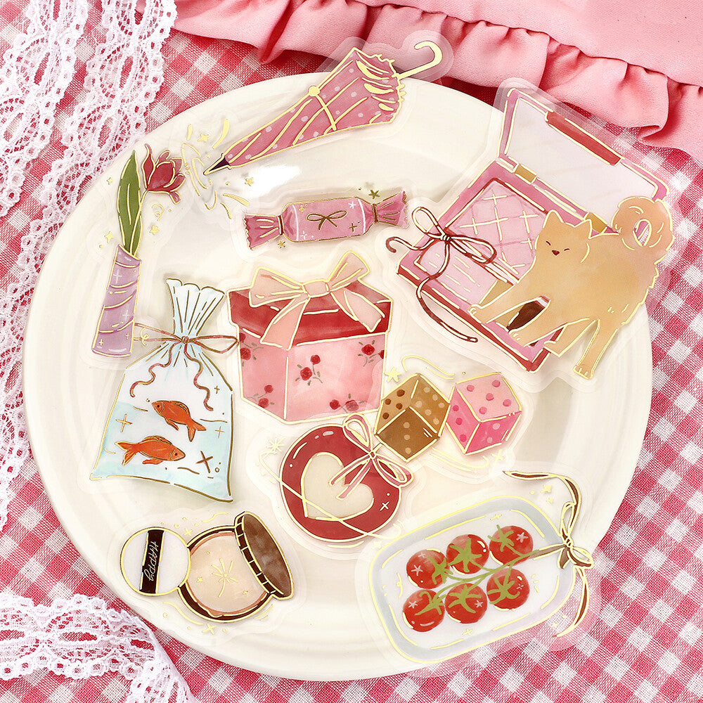 Set of cute, transparent paper clips with various designs on a white plate.