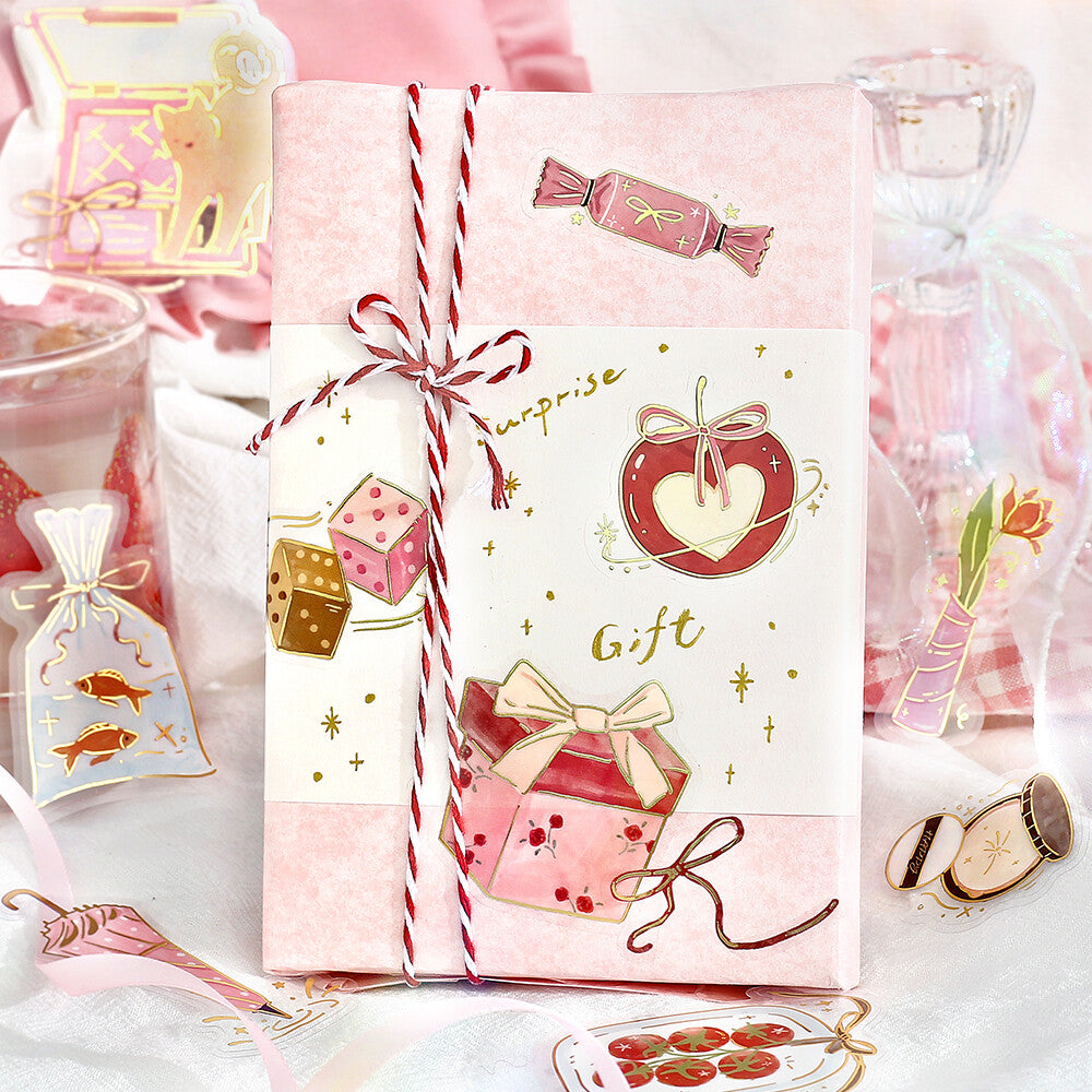 Gift box with decorative paper and ribbons on a pink background