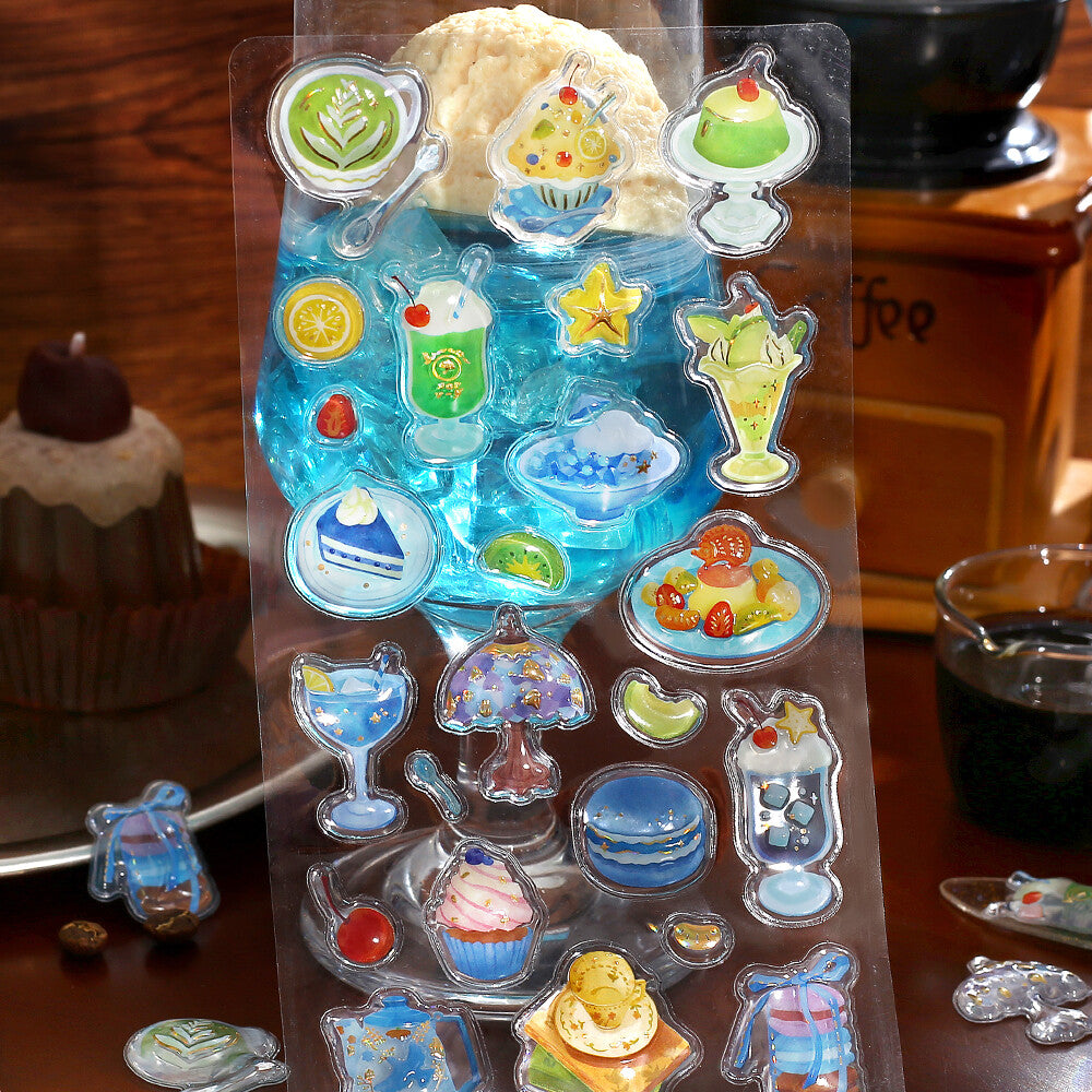 Transparent sheet with colorful dessert illustrations on a wooden surface.