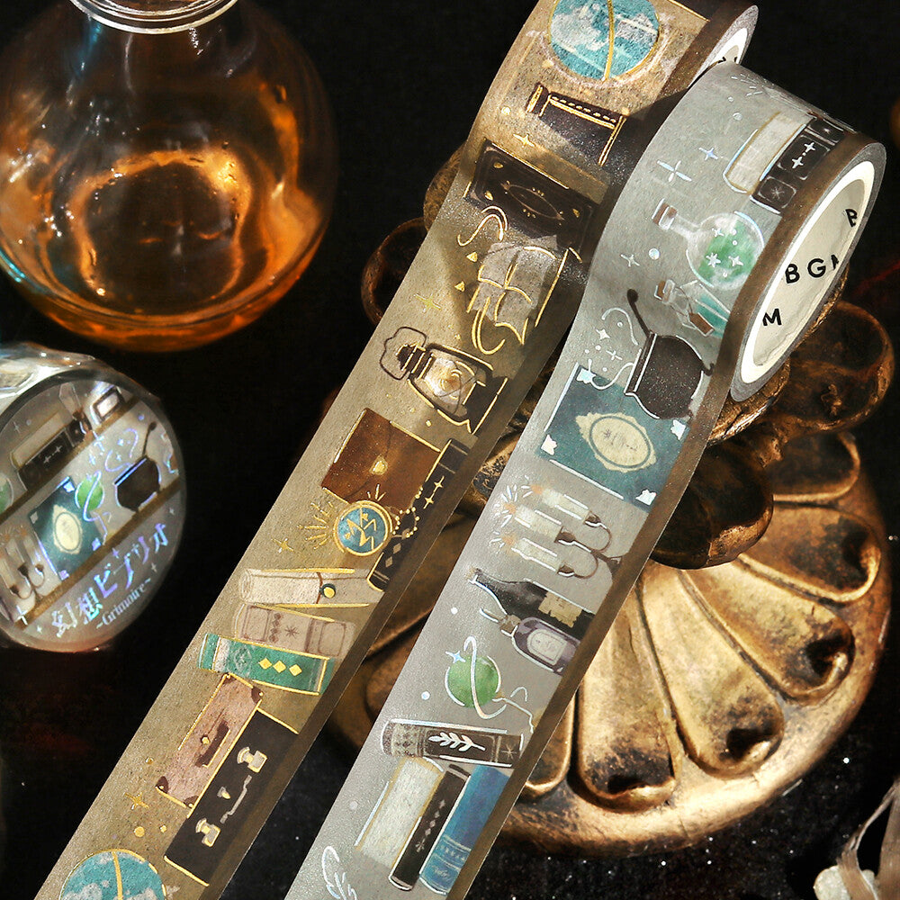 Two rolls of decorative tape with intricate designs on a dark surface.