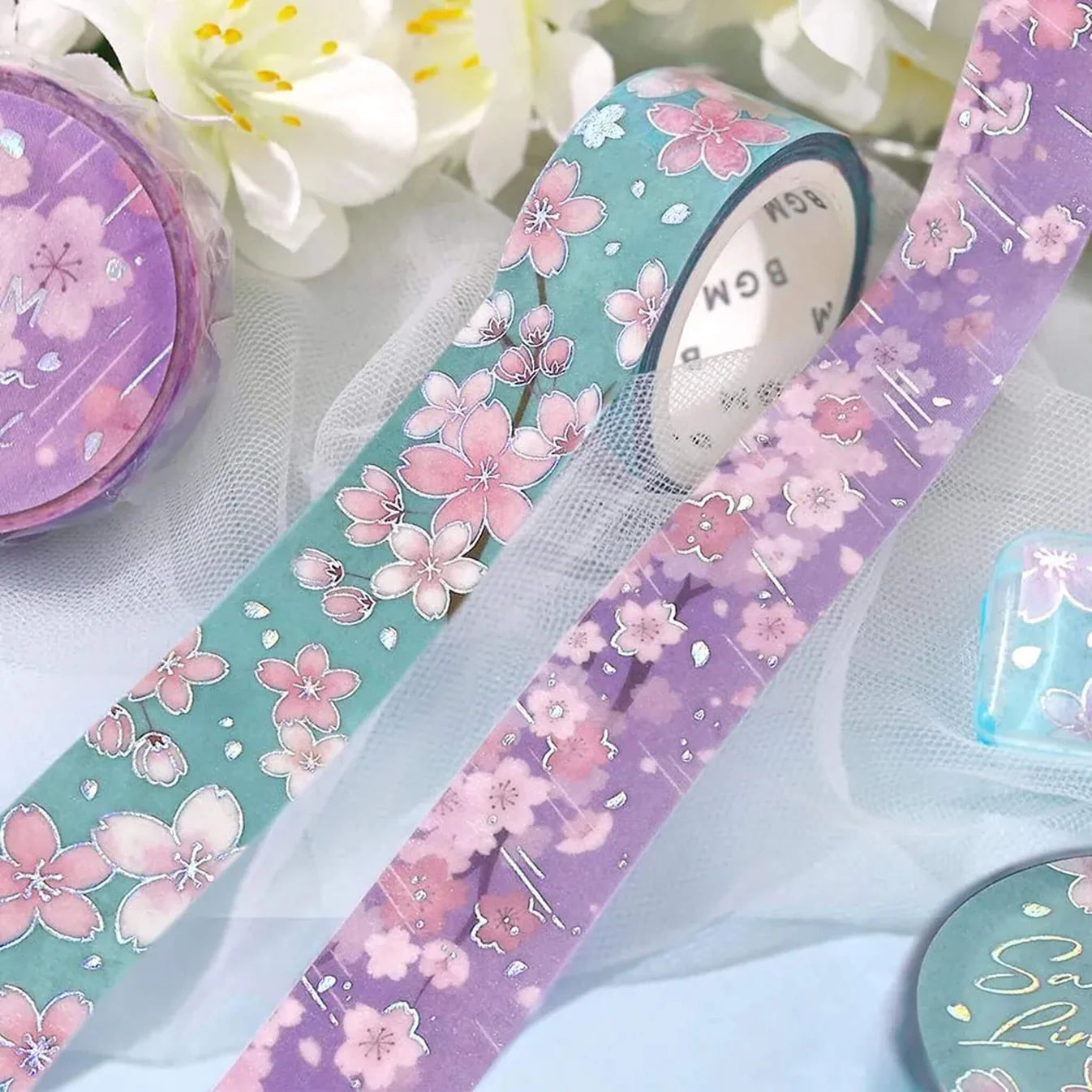 Two washi rolls with cherry blossom flowers on a tuille background