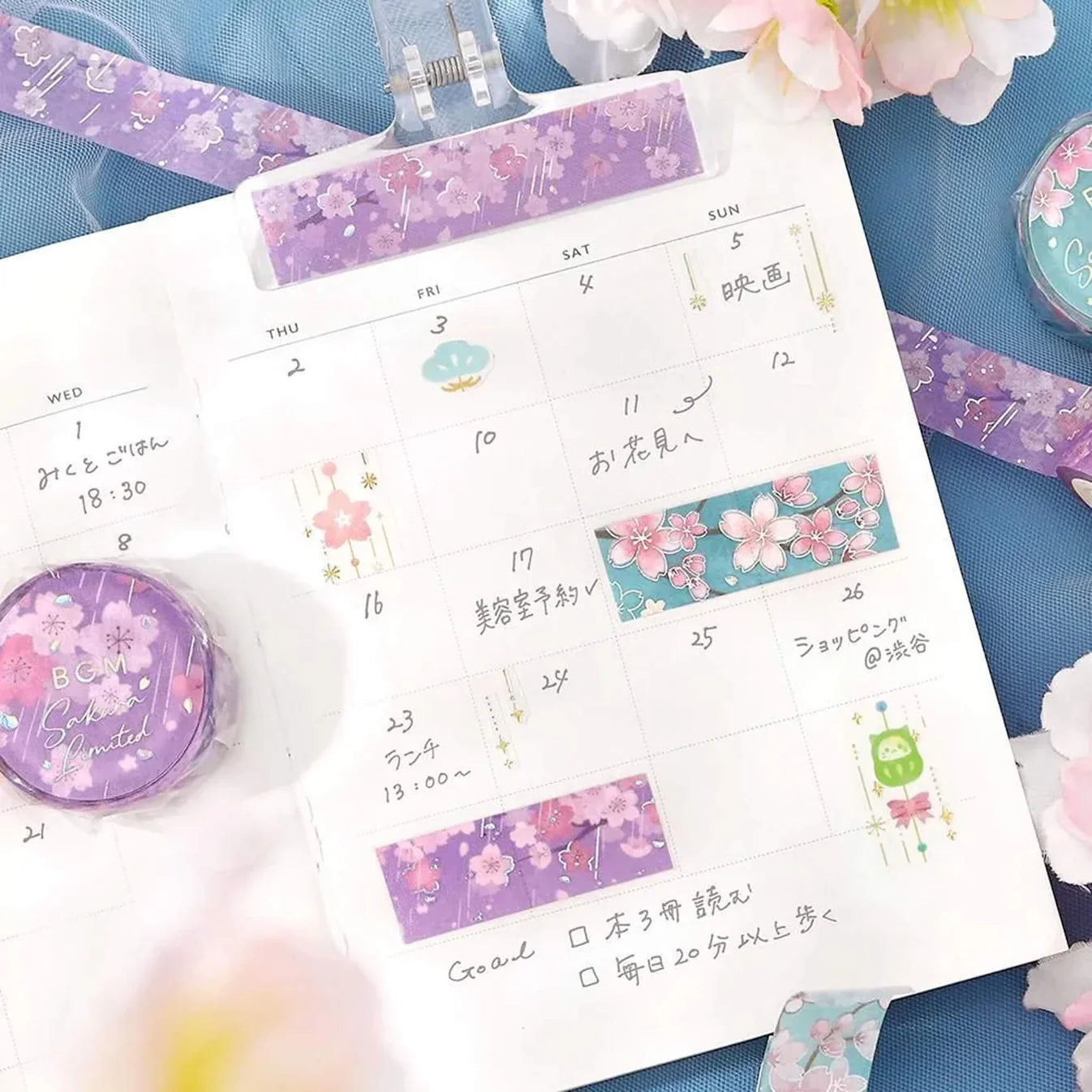 Planner with decorative washi tape on a blue surface