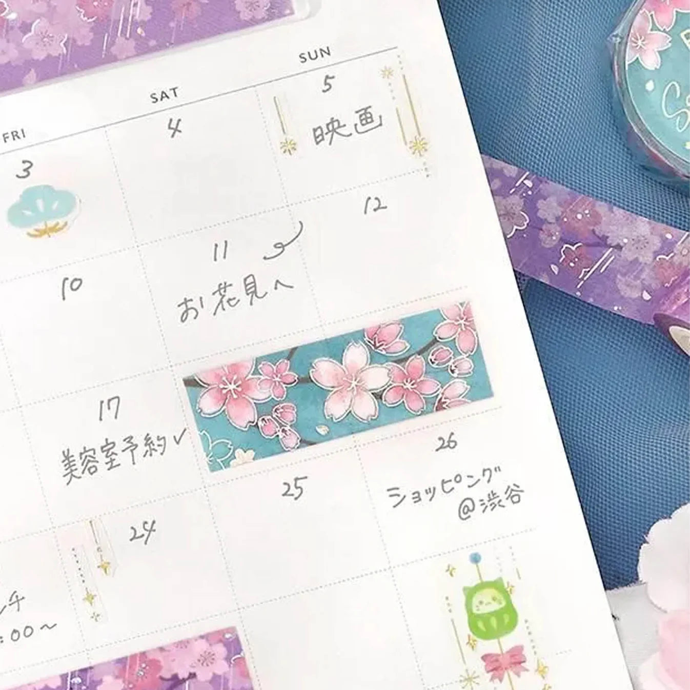Calendar with cherry blossom designs and decorative washi tape on a blue surface
