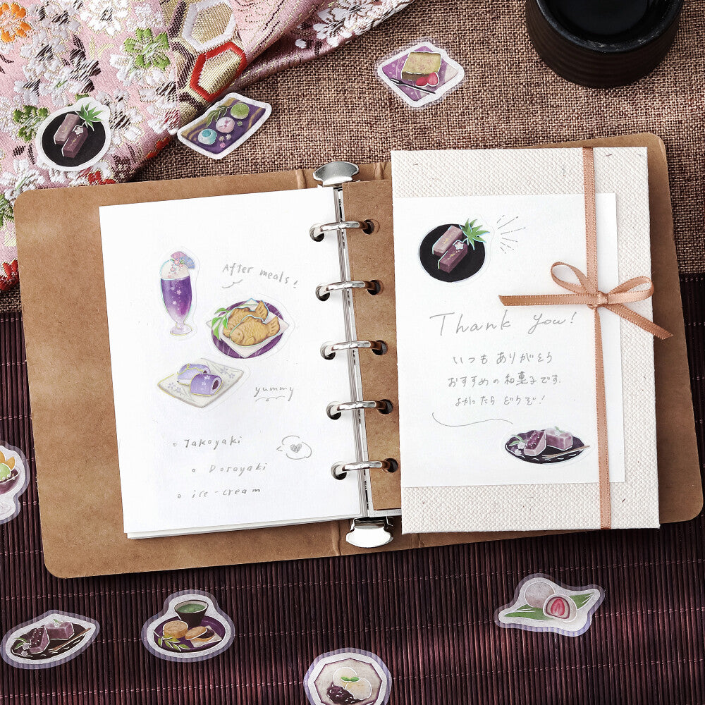 Open notebook with illustrations and text on a textured surface with decorative elements.