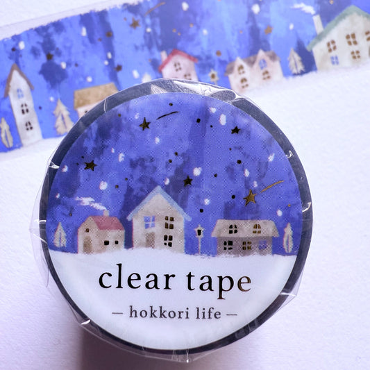 Clear tape with a decorative label featuring small houses and stars on a blue background.