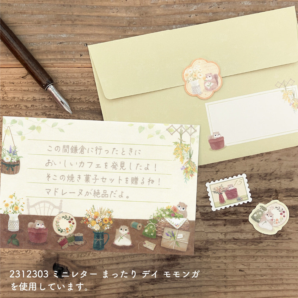 Stationery set with envelopes, cards, and decorative stamps on a wooden surface.