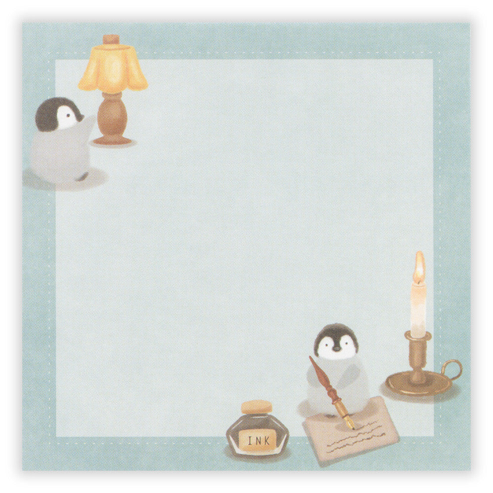 Notepad with penguin design, lamp, candle, and inkwell on a light blue background