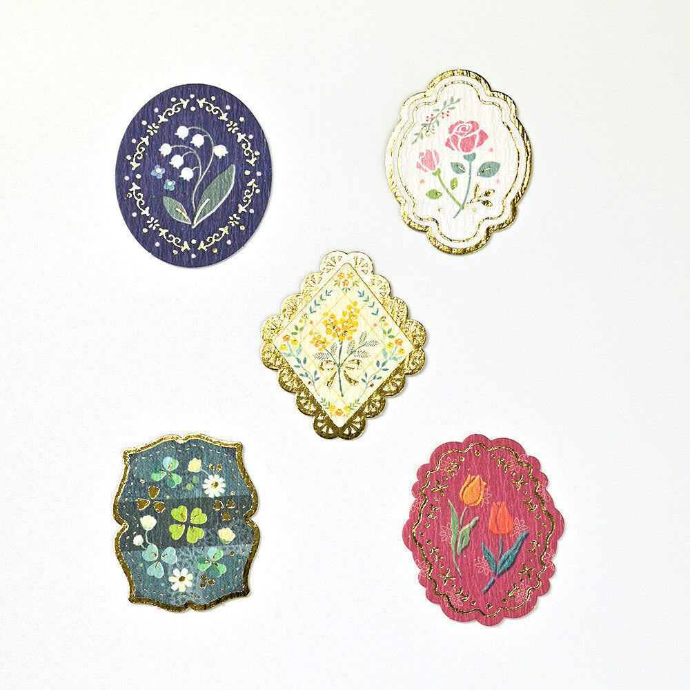 Set of five decorative coasters with floral designs on a white background