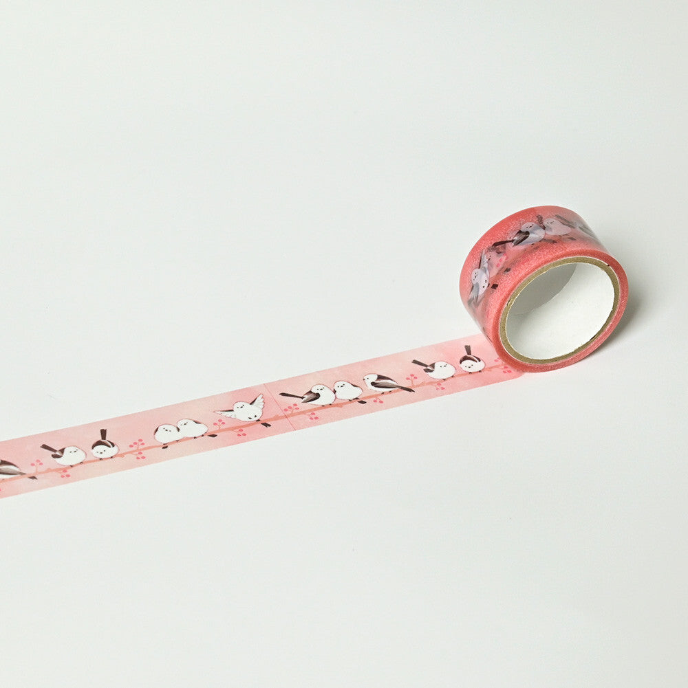 Roll of pink decorative tape with a pattern on a light gray background