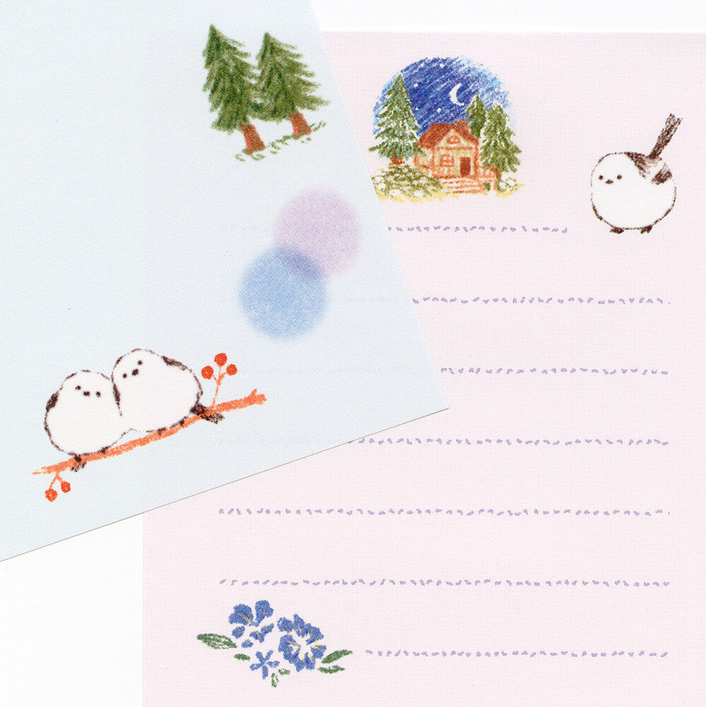 Stationery set with winter-themed illustrations including snowmen, trees, and a cabin.