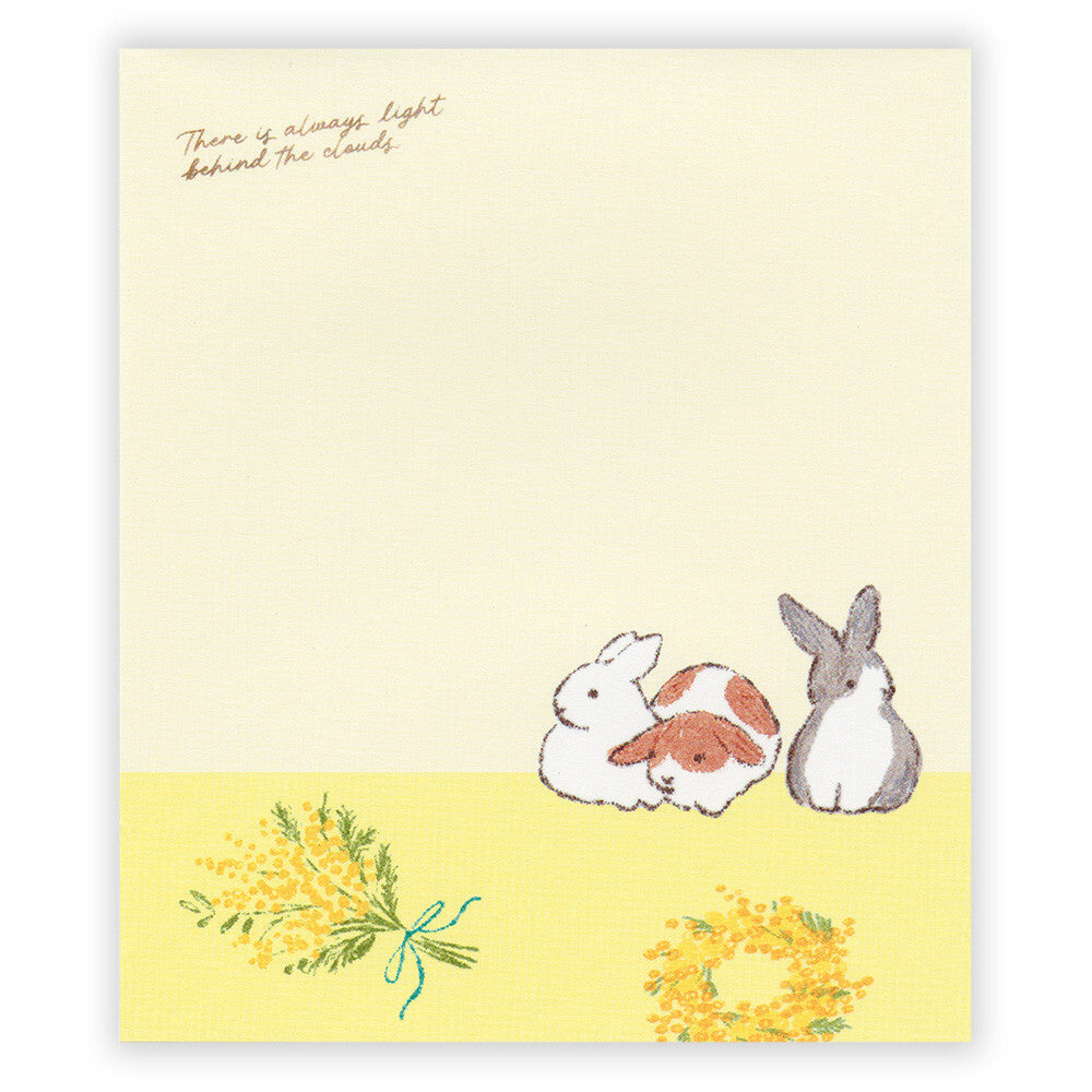 Notebook with cartoon bunnies and flowers on a light yellow background