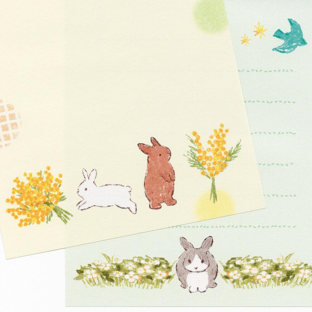Stationery set with rabbit and flower illustrations on a light background
