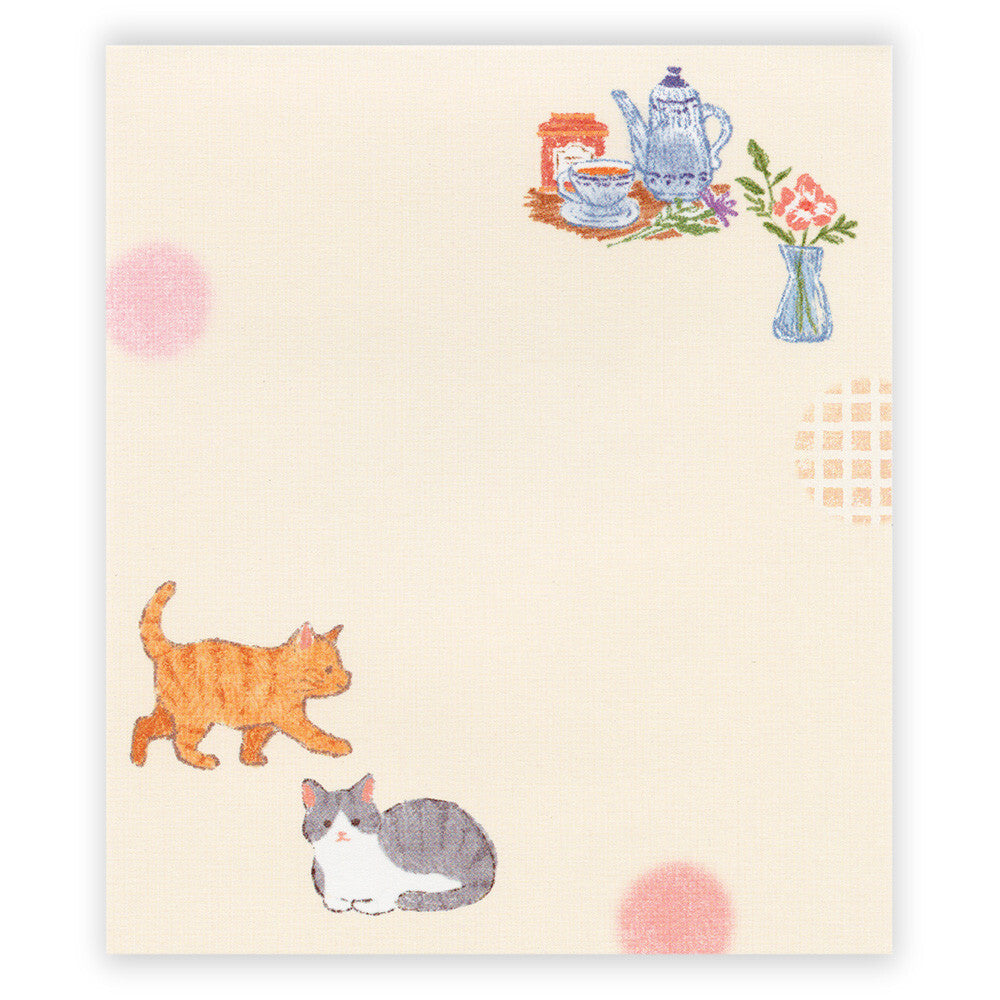 Notebook with cat illustrations and a tea set on a beige background