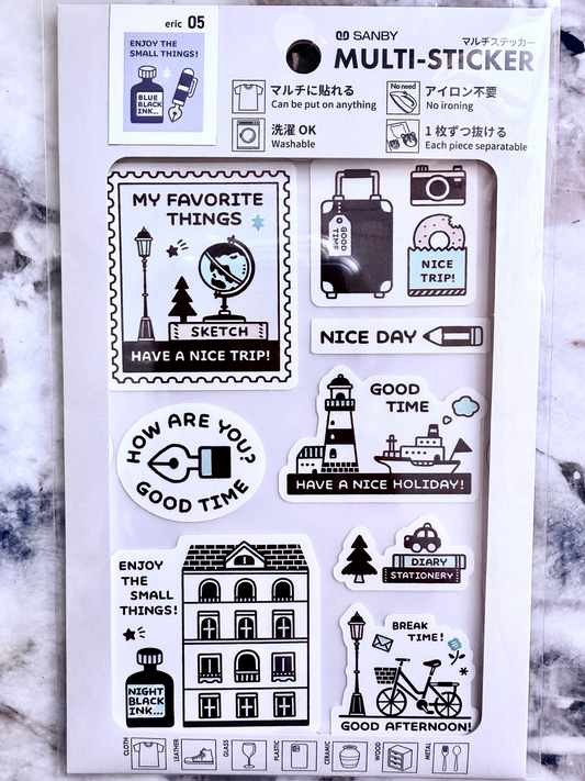 Set of black and white stickers on a white card with text, against a marble background.